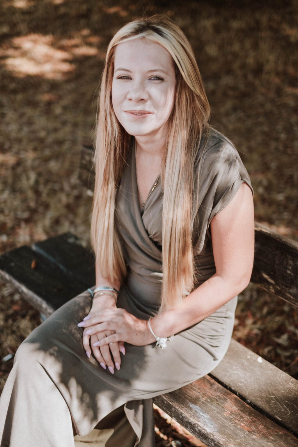 Danielle Hunter sitting on a wooden bench in dappled sunlight